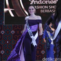 Jolene Marie dari Sulawesi Utara tampil dramatis dengan jumpsuit ungu off the shoulder, yang diberi ornamen train berterbangan ketika ia melangkah. Foto: Mohammad Abduh/Wolipop