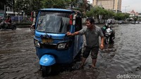 Uniknya, ada pula pengemudi bajaj yang memanfaatkan banjir untuk membersihkan bagian kendaraannya.
