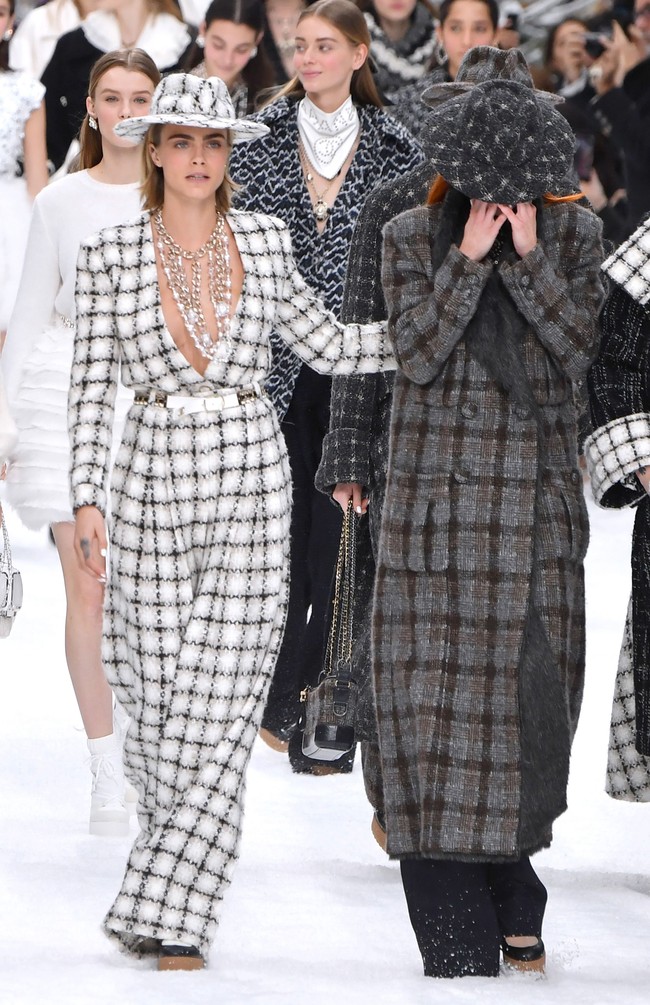 Model Cara Delevingne yang memimpin barisan para model tampak berusaha menenangkan rekannya yang menangis. Mereka muncul dalam balutan busana berwarna kelam, seolah masih berkabung atas kepergian Karl. Foto: Getty Images