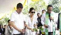 Mikha melemparkan bunga ke pusara sang ibu ditemani ayahnya. Pool/Palevi S/detikFoto.