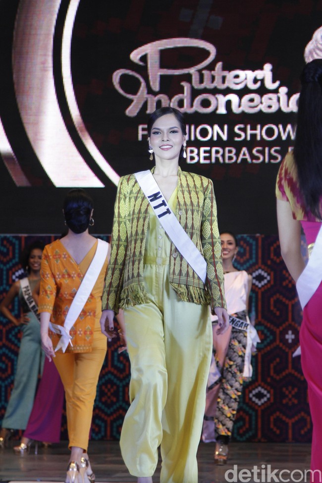 Perwakilan NTT, Maria Hostiana tak lagi asing di panggung catwalk. Wanita yang berprofesi sebagai model profesional ini cantik dibalut jumpsuit satin berwarna cerah, dengan jaket tenun senada. Foto: Mohammad Abduh/Wolipop