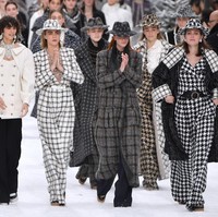 Cara, model yang cukup dekat dengan Karl, terlihat tegar. Ia memesona dengan jumpsuit putih bermotif kotak dalam bahan tweed khas Chanel. Foto: Getty Images