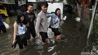 Beberapa warga terlihat semringah saat menerobos banjir.