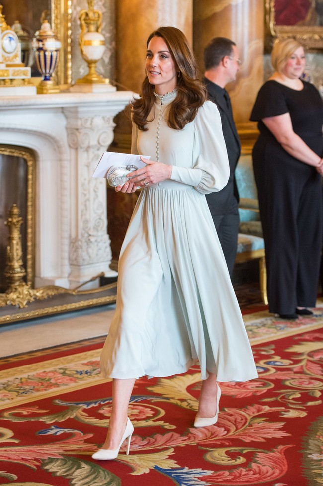 Di lain sisi ada Kate Middleton yang setia dengan model gaun feminin bergaya klasik. Kate memilih warna hijau pucat kali ini dan memadukannya dengan high heels nude. Foto: Dok. Getty Images