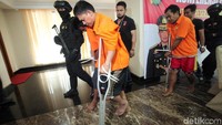 Dua orang pelaku yang ditembak kakinya berjalan sambil terpincang-pincang.