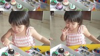 Ini aksi gemes Kala saat tak sabar mencolek-colek cream cupcake di hadapannya. Foto: Instagram kalamadali