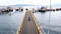 Pekerja melintas di dermaga Pelabuhan Ketapang, banyuwangi, Jawa Timur, kamis (7/3/2019). ANTARA FOTO/Budi Candra Setya.