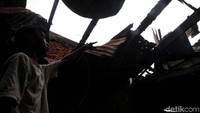 Seorang warga menunjukkan atap rumahnya yang telah hangus dilalap api akibat kebakaran yang terjadi di Johar Baru.