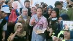 Momen Menteri Rini Cicipi Nasi Bungkus Pengungsi Banjir di Madiun