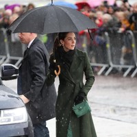Hujan bukan pengahalang bagi Kate untuk tetap bergaya maksimal. Sambil berlindung di bawah naungan payung hitan, ia muncul dengan mantel hijau gelap dari label Sportmax. Foto: Getty Images