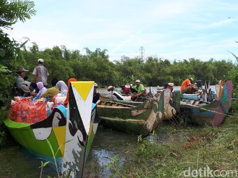 Warga yang terisolasi harus menggunakan perahu kecil untuk keluar rumah
