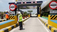 Para pekerja tengah memasang papan petunjuk di gerbang tol Marelan 2. Pool/Hutama Karya.