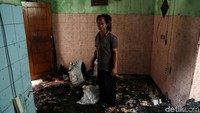 Seorang warga berada di dalam rumah yang terdampak kebakaran di pemukiman padat penduduk di Johar Baru, Jakarta Pusat.