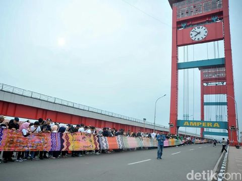 Jokowi Hadiri Pemecahan Rekor Muri Kain Jumputan 1,1 KM di Jembatan Ampera