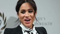 Ia tampil kasual dengan gaun pendek yang dipadukan dengan kardigan hitam. Foto: Meghan Markle (Daniel Leal-Olivas/Getty Images)