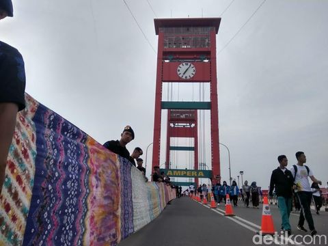 Jokowi Hadiri Pemecahan Rekor Muri Kain Jumputan 1,1 KM di Jembatan Ampera