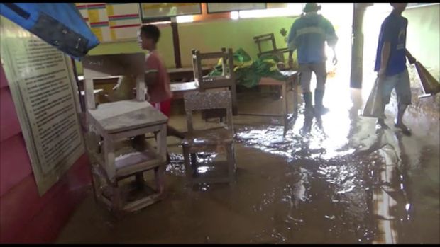 Guru dan siswa membersihkan sekolah dari sisa-sisa banjir.