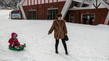 Seorang ibu sedang menarik kereta luncur yang ditumpangi seorang anak di di Resor Ski Masikryong. (Foto: Carl Court/Getty Images)