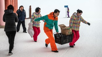 Kalau yang ini rombongan pekerja di Resor Ski Masikryong sedang bahu-membahu membawa barang berat. (Foto: Carl Court/Getty Images)