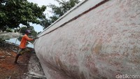 Seorang perajin tampak menyelesaikan pembuatan perahu tersebut.