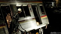 Sejumlah petugas mengaitkan tali ke gerbong yang akan diangkat.