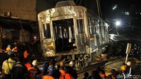 Gerbong KRL yang keluar lintasan mulai diangkat.