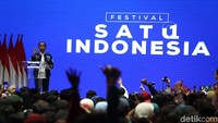 Jokowi menghadiri acara Festival Satu Indonesia dengan mengenakan jaket bomber biru donker.