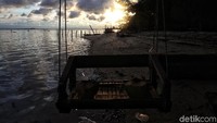 Sambil menunggu senja, ada pula pengunjung yang menikmati es kelapa sambil bermain di bibir pantai Pulau Tidung, Kepulauan Seribu.