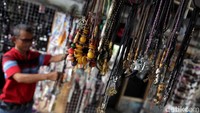 Seorang pedagang memperlihatkan barang dagangannya berupa gelang, kalung dan pernak-pernik lainnya di Pulau Harapan, Kepulauan Seribu.