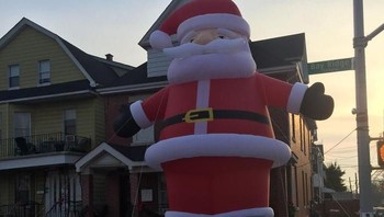 Ketika penjual mengirimkan ukuran boneka udara Santa Clause yang tak sesuai pesanan, akhirnya dipajang depan rumah saja. (Foto: Boredpanda)