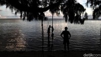 Seorang pengunjung menanti senja di bibir pantai Pulau Tidung, Kepulauan Seribu.