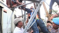 Setelah negosiasi dilakukan, Aming turun bersama Iwan dan anaknya. Sekitar 30 menit, Aming bersama petugas pemadam kebakaran, polisi, dan warga mengevakuasi Iwan dan anaknya turun dari ketinggian. (Foto: dok. Pemkab Purwakarta)