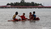 Anak-anak nampak asyik bermain air usai terjun bebas dari Jembatan Cinta.