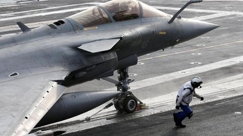 Petugas berlari sambil mengarahkan pesawat. Foto: Reuters