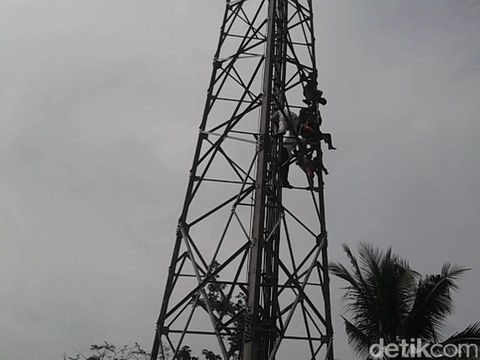 Nekat! Pria Gendong Anak Panjat Tower Ancam Bunuh Diri di Purwakarta