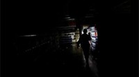 Seorang pegawai toserba meninjau kerusakan di sebuah toko yang dijarah di Caracas. (Foto: Dok. Reuters)