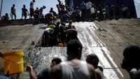 Warga mengambil air dari selokan yang mengalir ke Sungai Guaire (Foto: Dok. REUTERS/Carlos Garcia Rawlins)