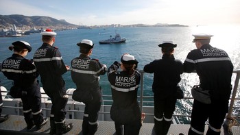 Awak kapal Charles de Gaulle menatap pelabuhan Toulon saat meninggalkan Prancis. Foto: Reuters