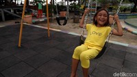 Seorang anak tertawa gembira saat bermain ayunan di Ruang Publik Terpadu Ramah Anak (RPTRA) Tidung Ceria di Pulau Tidung, Kepulauan Seribu.