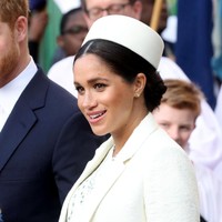 Mantan aktris itu juga memakai coat putih untuk menghangatkan tubuh dari udara dingin London. Menariknya, topi bergaya peci turut memaksimalkan gayanya. (Foto: Getty Images)