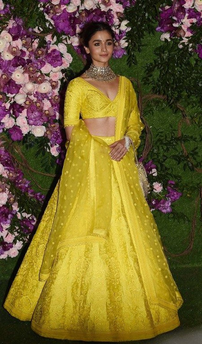 Alia Bhatt terlihat manis dengan lehenga berwarna kuning cannary. Kalung besar bernuansa perak nampak menyeimbangkan warna mencolok pada gaun. Foto: SUJIT JAISWAL / AFP