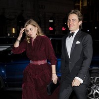 Putri Beatrice tampil elegan dalam balutan gaun merah berbahan beludu atau velvet yang dipadu clutch dan stocking hitam. Tidak ketinggalan heels hitam bergaya mary-jane, juga berbahan beludu, turut menyempurnakan gaya cucu Ratu Elizabeth II itu. Adapun Edoardo tampak gagah dengan tuksedo hitam. Foto: Getty Images