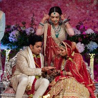 Abu Jani Sandeep Khosla merancang busana pengantin keduanya. Busana dihiasi bordiran yang dibuat secara khusus dan handmade. Mempelai wanita mengenakan lehenga paduan warna merah-emas, sementara Akash Ambani tampil mewah sekaligus elegan dalam setelan sherwani warna emas. Foto: Reliance Industries/Handout via REUTERS ATTENTION EDITORS