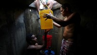 Warga Venezuela berkumpul di salah satu gorong-gorong dengan membawa ember untuk mendapatkan air. Ivan Alvarado/Reuters.