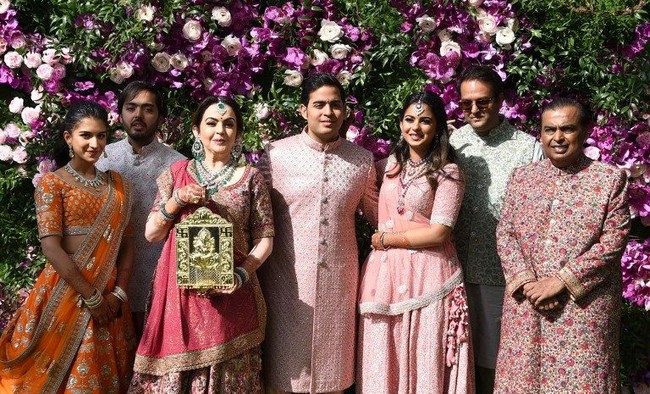 Dalam salah satu rangkaian adat upacara pernikahan, Akash Ambani tampak mengenakan tunik aksen bordir warna pink pastel. Busananya senada dengan sang adik Isha Ambani dan ayah mereka, Mukesh Ambani. Foto: SUJIT JAISWAL / AFP