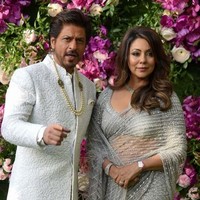 Shah Rukh Khan berpose bersama sang istri yang juga seorang produser Gauri Khan. Keduanya tampil kompak dalam balutan warna perak. Foto: SUJIT JAISWAL / AFP