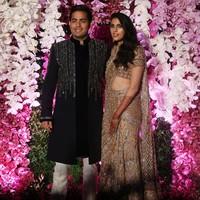 Upacara pernikahan dilanjutkan dengan resepsi di lokasi yang sama. Kali ini Akash dan Shloka mengenakan busana yang lebih santai namun tetap mewah. Pria 27 tahun tersebut terlihat memakai tunik hitam bertabur payet, sang istri berbusana sari yang juga dipenuhi payet berkilauan. Foto: REUTERS/Francis Mascarenhas