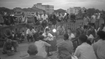 Para buruh bercengkrama di Read Bridge di tahun 1960, lima tahun sebelum kemerdekaan dari Malaysia. Foto: Reuters