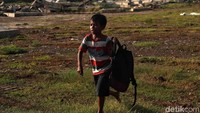 Seorang bocah berjalan di lokasi yang akan dibangun stadion kelas dunia.