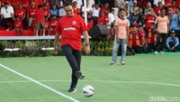 Anies menendang bola sebagai simbol kick off pembangunan di kawasan Taman BMW. Suporter Persija, The Jak Mania, dan Persitara Jakarta Utara.